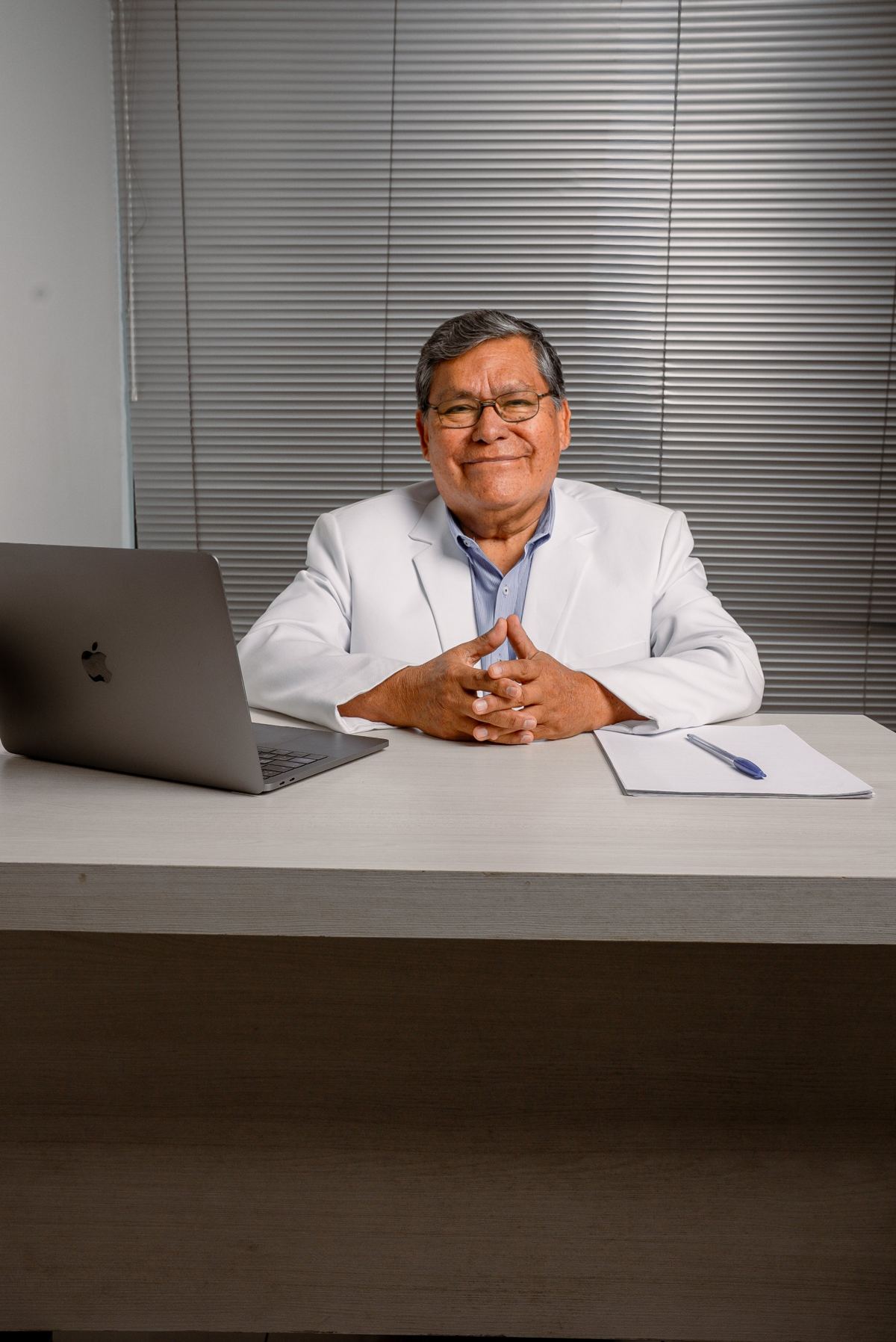 Dr. Ricardo Valdivieso sonriendo en su escritorio